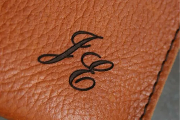 Monogrammet JE graverat i brunt läder
